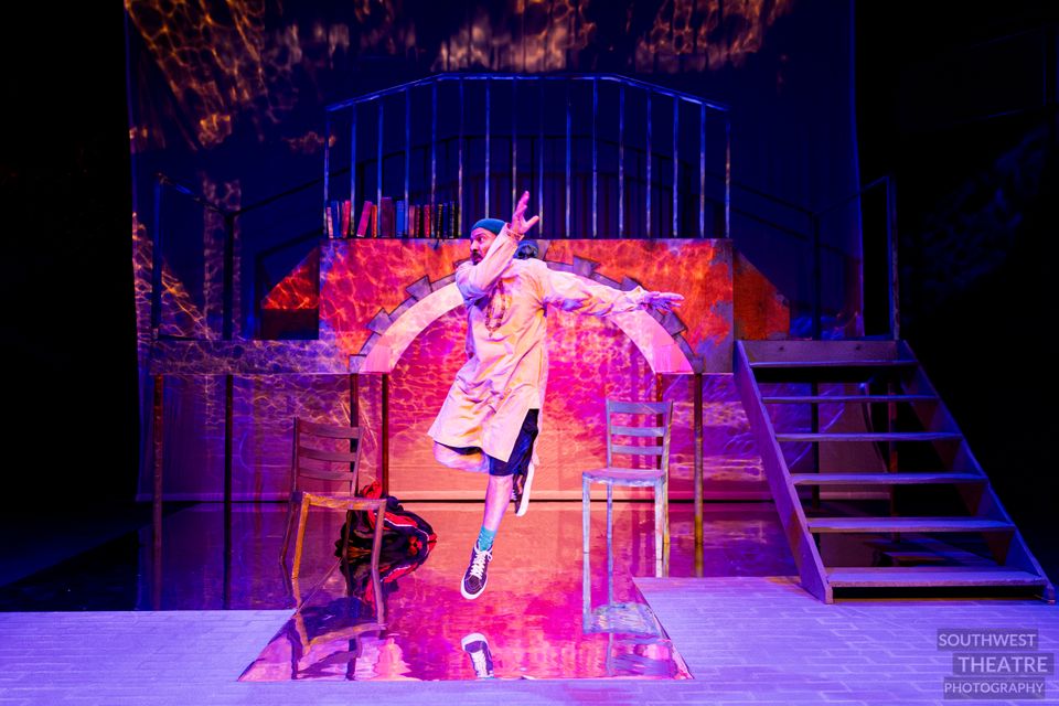 A man on stage is jumping in the air